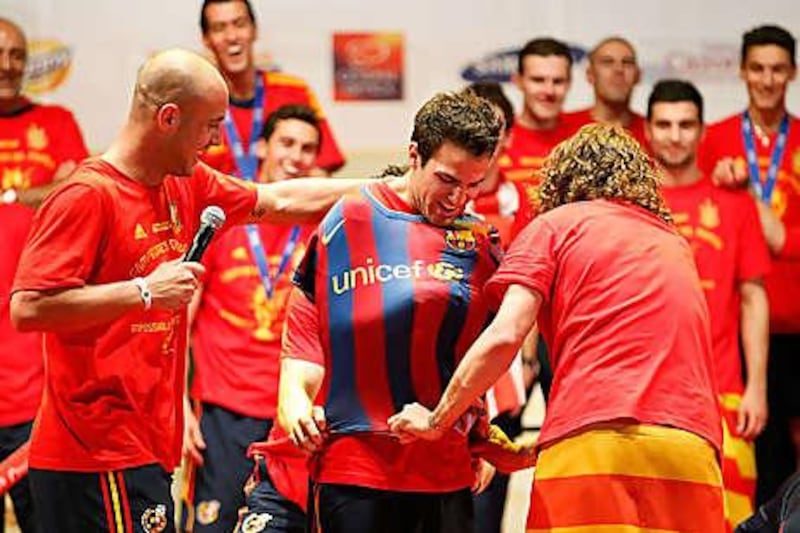 Pepe Reina and Carles Puyol jokingly put a Barcelona shirt on Spanish teammate Cesc Fabregas during the team's World Cup victory parade, but will he be wearing one for real next season?