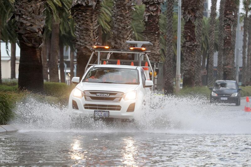 Vehicles navigate floodwater on Riverside Drive near the Swan River, which is partially closed due to storm flooding, in Perth, Western Australia.  EPA