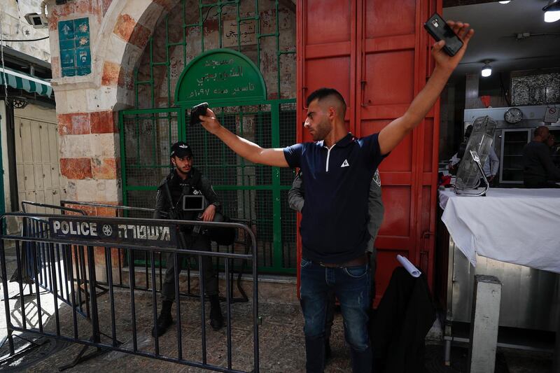 Israeli policemen conduct a physical search of a Palestinian man at the alleys of the Old City of Jerusalem on April 29, 2021. EPA