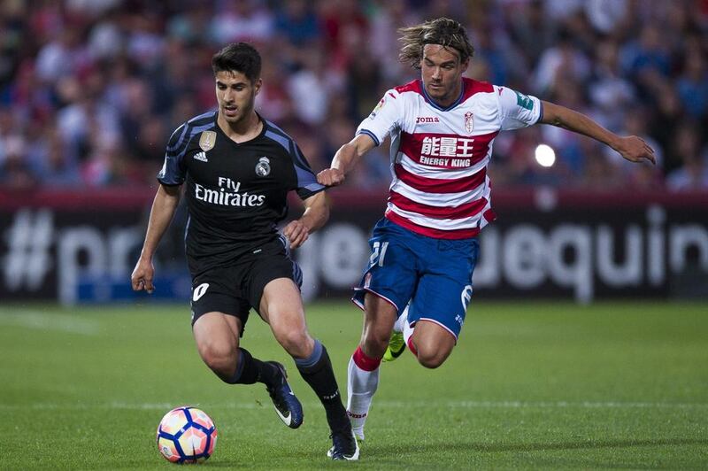 Real Madrid’s Marco Asensio, left, duels for the ball against Granada’s Rene Krhin. Daniel Tejedor / AP Photo