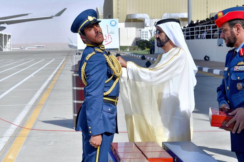 Sheikh Mohammed bin Rashid, Vice President, Ruler of Dubai and Minister of Defence, pins a badge onto a graduating cadet. Wam