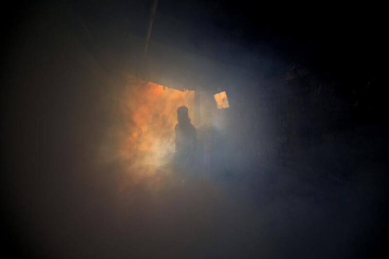 A municipal worker fumigates an alley of an impoverished colony to check the spread of mosquito-borne diseases in New Delhi.  Manish Swarup / AP Photo