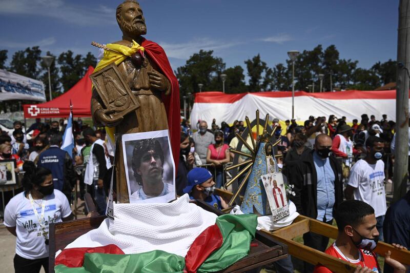 A picture of Maradona next to a statue of Saint Roch, during a charity event in Villa Palito, San Justo, La Matanza. AFP