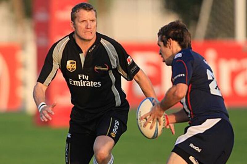 Dubai Hurricanes’ Steve Smith, left, runs down a  Dubai Dragons opponent at The Sevens.