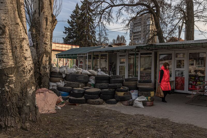 A woman walks past a fortification made with tyres in Zaporizhzhia, Ukraine. EPA