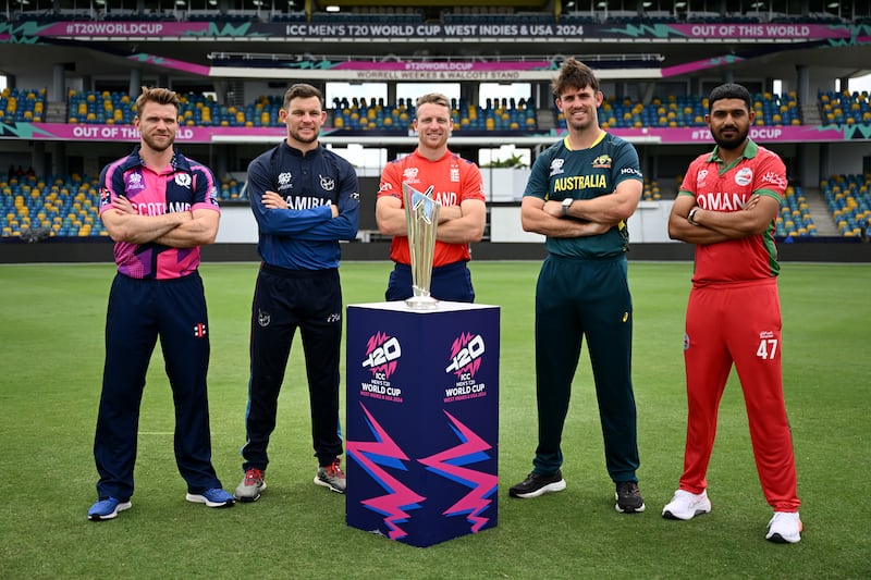 Group B captains Richie Berrington of Scotland, Gerhard Erasmus of Namibia, Jos Buttler of England, Mitchell Marsh of Australia and Aqib Ilyas of Oman pose with the T20 World Cup trophy. Getty Images