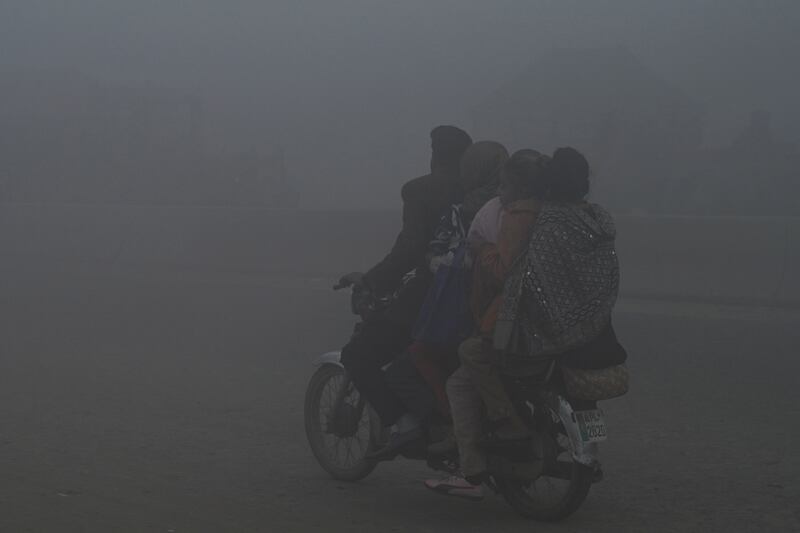 Commuters on a street during heavy smog in Lahore, Pakistan. AFP