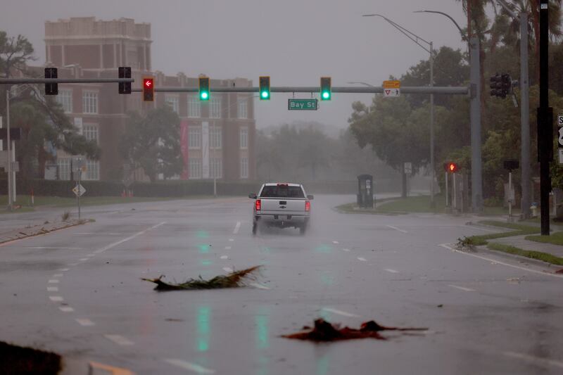 A vehicle drives through the wind and rain from Hurricane Ian in Sarasota, Florida.  AFP