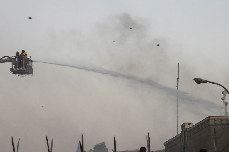 Firefighters spray water on the embassy building in Iraq's capital to put out the blaze started by protesters. Reuters
