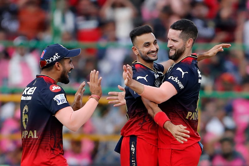 Royal Challengers Bangalore's Wayne Parnell, right, celebrates after claiming the wicket of Rajasthan Royals batter Joe Root in the IPL on May 14, 2023. AP