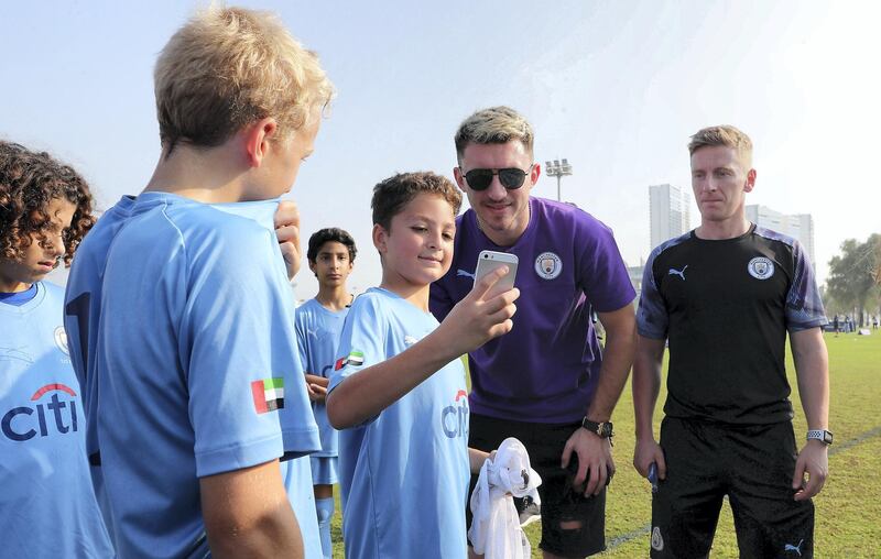 ABU DHABI, UNITED ARAB EMIRATES , Nov 30 – 2019 :- Students of Manchester City football school Abu Dhabi taking their photos with Aymeric Laporte, French footballer at the Zayed Sports city in Abu Dhabi. ( Pawan Singh / The National )  For Sports. Story by Jon Turner 