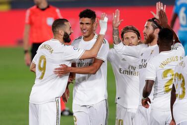 Real Madrid's Karim Benzema, left, celebrates with his teammates after scoring his side's third goal during the Spanish La Liga soccer match between Real Madrid and Valencia at Alfredo di Stefano stadium in Madrid, Spain, Thursday, June 18, 2020. Real Madrid won 3-0. (AP Photo/Manu Fernandez)