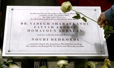 An unidentified man places a rose on a memorial plaque in front of the Mykonos restaurant in Berlin where four Iranian Kurdish dissidents were gunned down in 1992 on April 23, 2004. The plaque attributed the attack to Tehran, a verdict shared by a German court in 1997. Tehran city council said on Thursday it will erect plaques denouncing Germany as a supplier of chemical weapons to Iraq in retaliation for the plaque in Berlin accusing Iran of killing four Kurds 12 years ago. REUTERS/Manuela Hartling  MAD