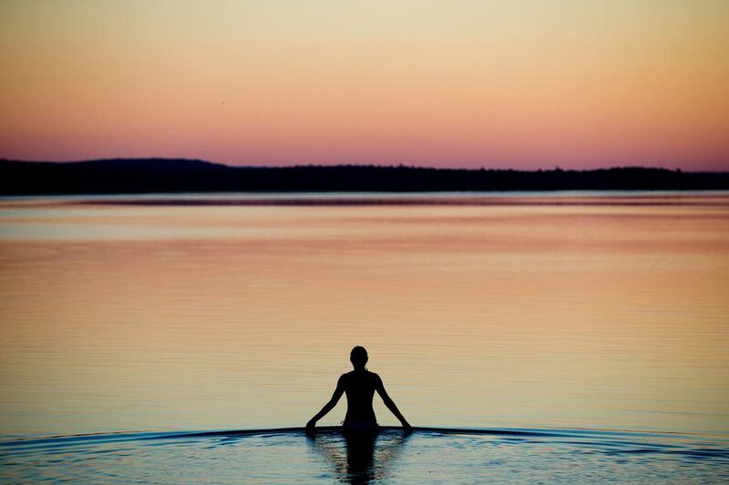 A young woman wades into the shallow waters of the Brombach Lake near Pleinfeld, Bavaria state, Germany, as the sun sets. Daniel Karmann / EPA