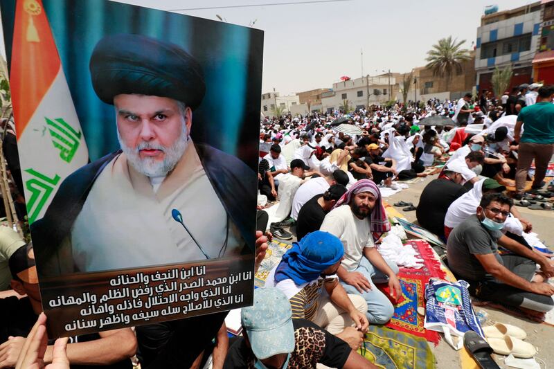 A supporter of Moqtada Al Sadr raises a placard in Sadr City, east of Baghdad. Talks to form a new government in Iraq have stalled. AFP