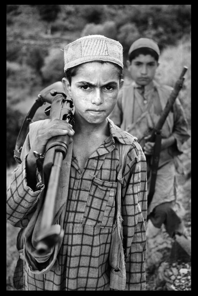 A young boy stands with his firearm, 1979. Copyright ©Steve McCurry / Magnum Photos