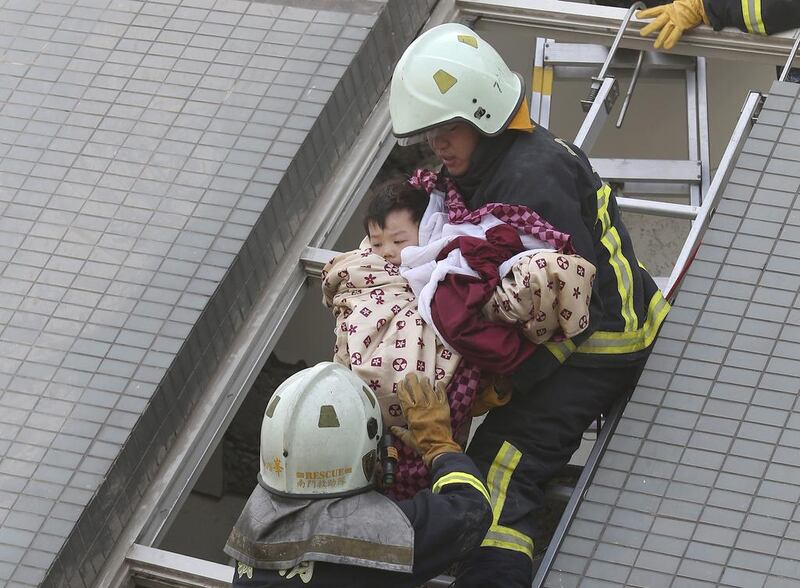 A child is rescued from a toppled building after a 6.4-magnitude earthquake in Tainan, Taiwan. The earthquake struck southern Taiwan early Saturday, toppling at least one high-rise residential building and trapping people inside. AP Photo