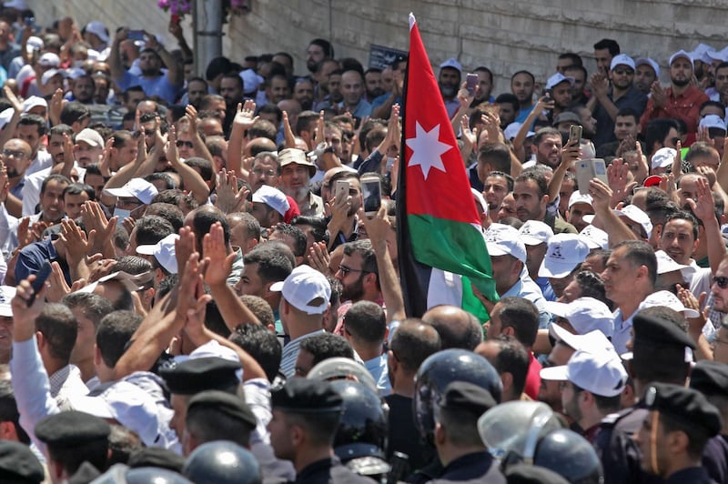 Jordanian teachers chant slogans and wave their national flag during a protest in the capital Amman.  AFP