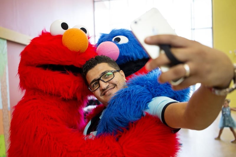 Mohammad Khawldeh takes a selfie with a couple of cuddly characters during the official launch event of Iftah Ya Simsim at Mubarak bin Mohammed school in Al Bateen, Abu Dhabi on Tuesday. Christopher Pike / The National