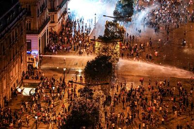 This picture taken from the top of the Arch of Triumph (Arc de Triomphe) on July 15, 2018 shows water canon dispersing people after clashes follwong celebrations of the Russia 2018 World Cup final football match between France and Croatia, on the Champs-Elysees avenue in Paris.  / AFP / Ludovic MARIN
