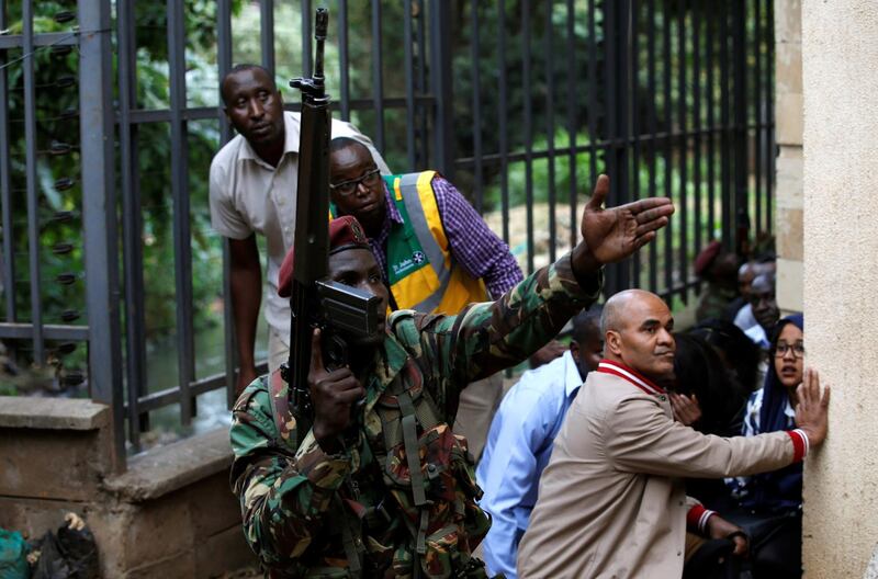A member of the security forces gestures as people take cover. Thomas Mukoya / Reuters