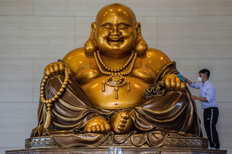 A Buddhist devotee cleans a giant Buddha statue ahead of Chinese Lunar New Year celebrations in Pekanbaru. AFP