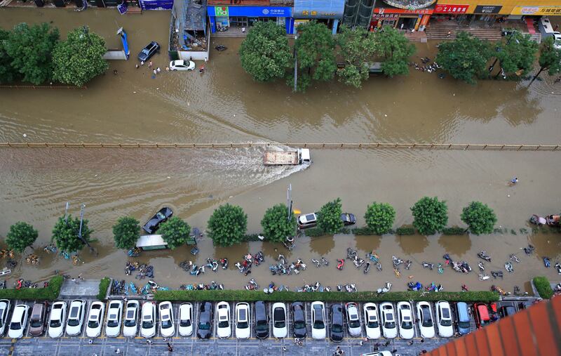 A truck travels on a flooded road after heavy rainfall in Zhengzhou, Henan province, China.