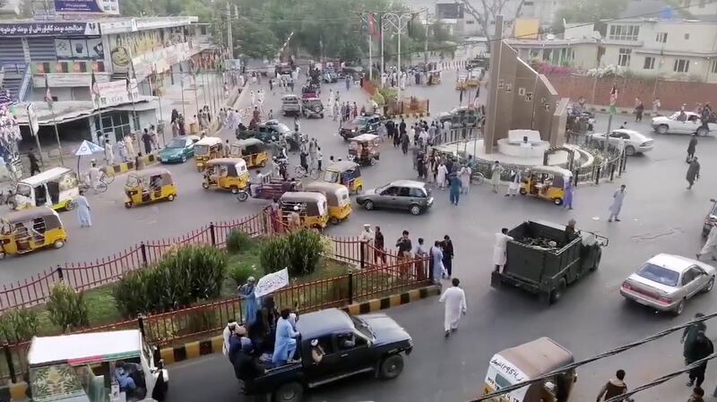 Militants wave a Taliban flag from the back of a pickup truck in Jalalabad.