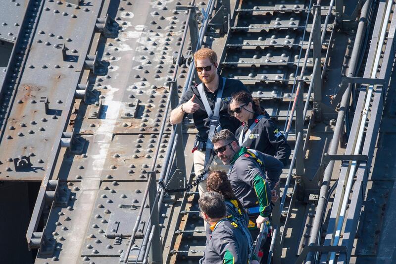 Prince Harry, top, climbs the Sydney Harbour Bridge, along with Mr. Morrison and Invictus Games competitors in Sydney. AP Photo