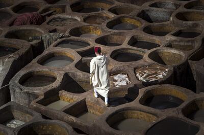 A Moroccan man walks in the tannery in the 9th century walled medina in the ancient city of Fez on April 11, 2019. In recent times the imperial city of Fez has been overlooked by tourists in favour of Marrakesh, but now Morocco's 'spiritual' capital is bustling with visitors thanks to major renovations and low-cost flights. Since 2013, more than one billion dirhams (92 million euros) of investments have been poured into Fez to restore the 9th century walled medina and develop tourism. / AFP / FADEL SENNA
