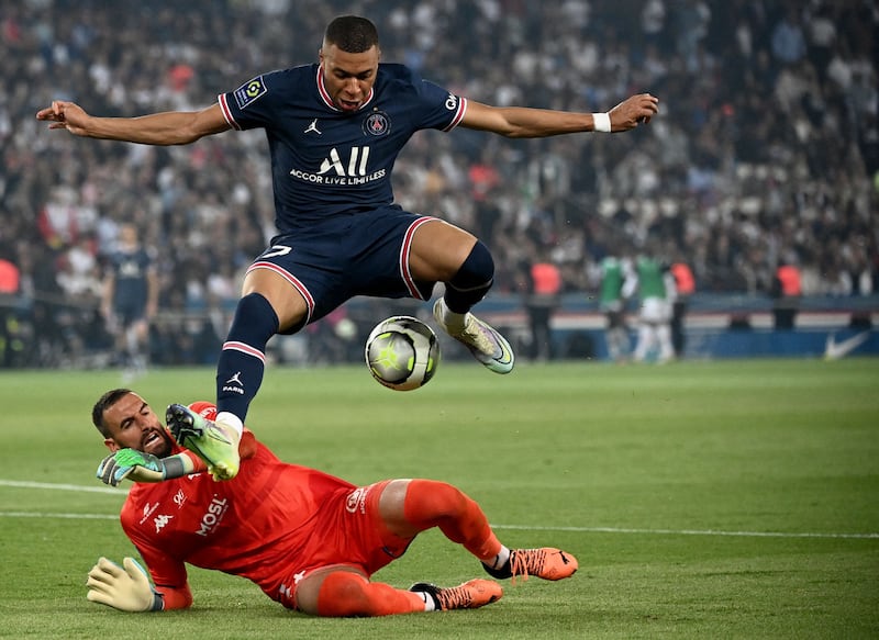 Mbappe jumps to avoid Metz's French goalkeeper Marc-Aurele Caillard. AFP