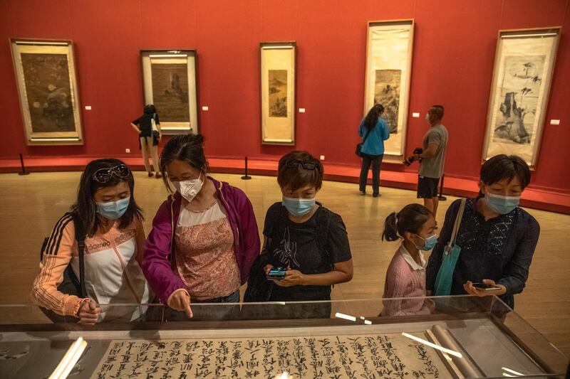 People wearing protective face masks visit 'A tribute to donors' exhibition at the National Art Museum of China on the first day after reopening, in Beijing, China, 13 May 2020.  EPA