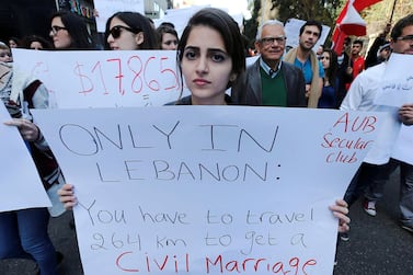 Lebanese protestors hold placards during a demonstration against the ongoing ban on civil unions in the Lebanese capital Beirut on March 1, 2015. AFP