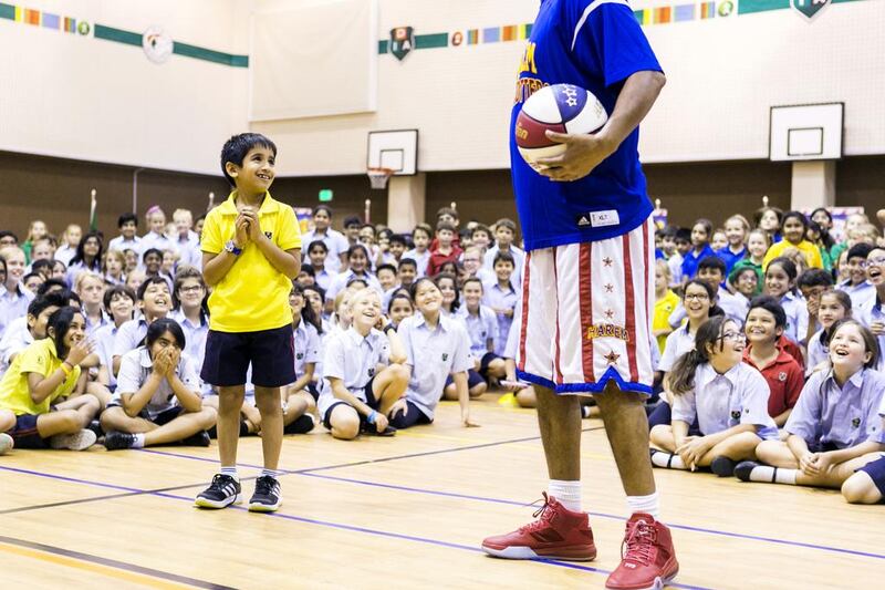 Handles enlists a pupil during the Harlem Globetrotters’ presentation at Dubai International Academy.  Reem Mohammed / The National