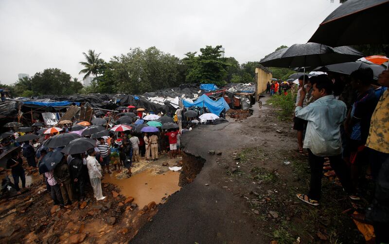 Rescuers and others gather at the spot after heavy rainfall caused a wall to collapse onto shanties, in Mumbai. AP Photo