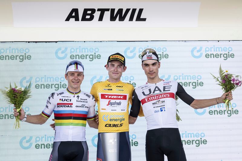Winner of the Tour de Suisse Mattias Skjelmose, centre, celebrates on the podium with second-placed Juan Ayuso, right, and Remco Evenepoel, who was third. AP