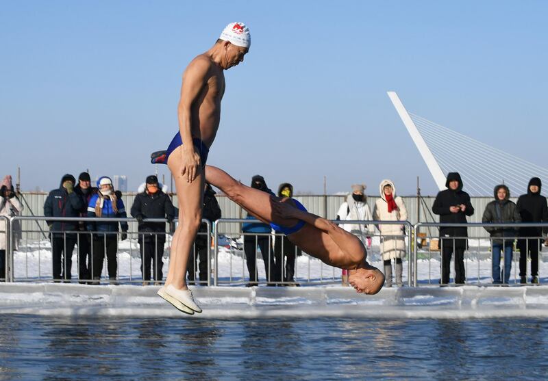 Winter swimmers dive from a platform into a swimming pool in subzero temperatures in Harbin, Heilongjiang province, China. Reuters