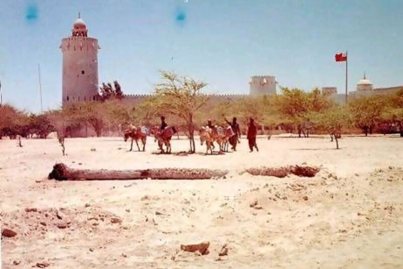 Men drive their donkeys past Qasr Al Hosn. Photo: John Vale