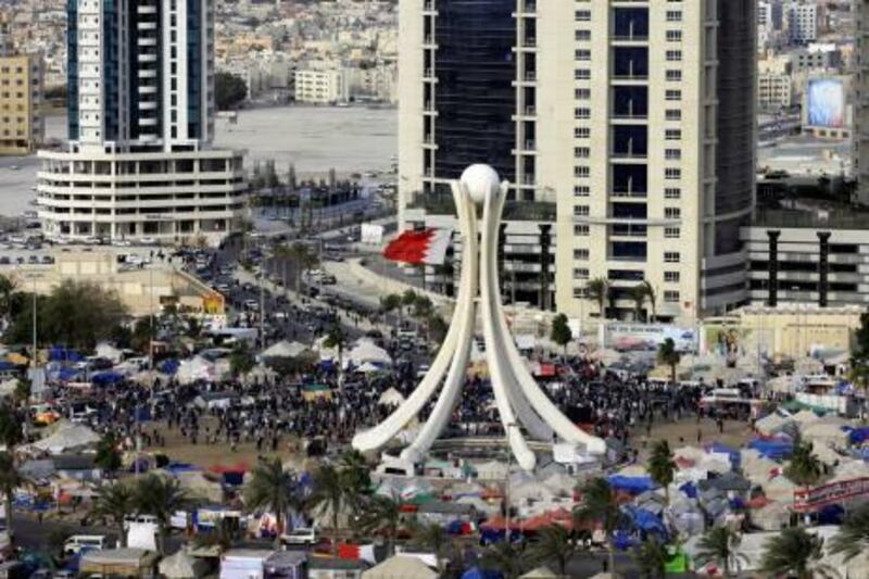 Protesters are seen at Pearl Square as Gulf Cooperation Council (GCC) forces move in to evacuate the area in Manama March 16, 2011. Helicopters flew overhead and Bahraini riot police fired teargas on Wednesday as they cleared mainly Shi'ite protesters from the central roundabout where they had been camped out for weeks, a Reuters witness said. REUTERS/Hamad I Mohammed (BAHRAIN - Tags: POLITICS CIVIL UNREST MILITARY IMAGES OF THE DAY)