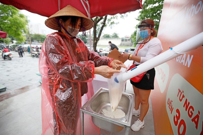 A woman receives free rice in Hanoi, Vietnam.  EPA