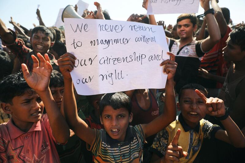 A boy holds a placard as hundreds of Rohingya refugees protest. Reuters