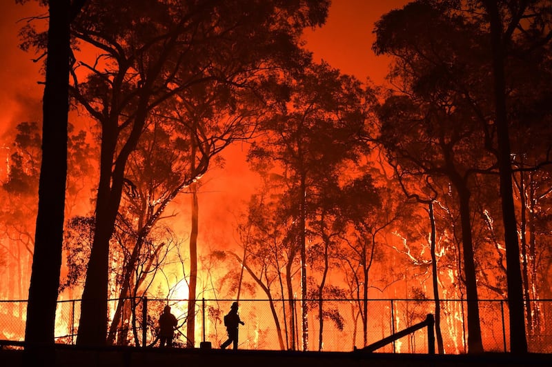 Volunteers and NSW Fire and Rescue officers protect the Colo Heights Public School from being hit by bushfires near Colo Heights south west of Sydney. EPA