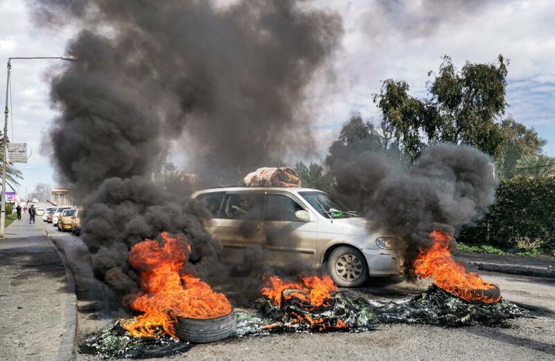 Vehicles are prevented from crossing as flaming tyres are placed at a make-shift roadblock along al-Nasr bridge in the city of Nasiriyah in Iraq's southern Dhi Qar province amidst ongoing anti-government demonstrations.   AFP