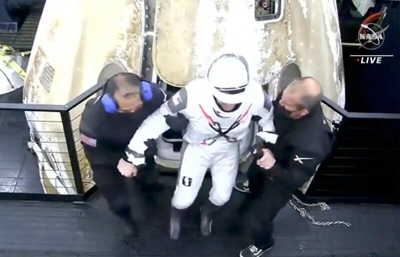 In this image from Nasa TV footage, Mike Hopkins is carried from the SpaceX Dragon capsule. After medical checks, the four astronauts were due to be reunited with their families. AP Photo