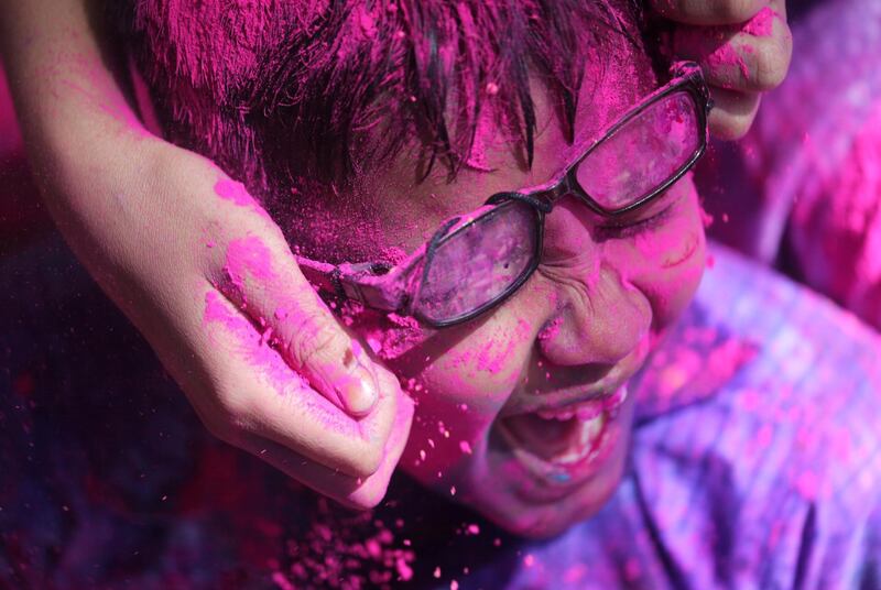 Children cover each other in coloured powder during Holi celebrations in Mumbai, India. Reuters