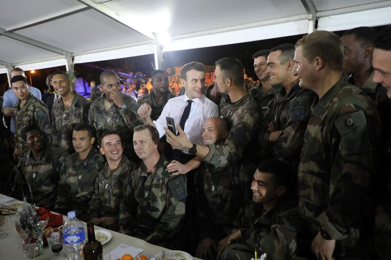 French President Emmanuel Macron (C) poses next to French soldiers during Christmas dinner with French troops at the Port-Bouet military camp near Abidjan, on the first day of his three day visit to West Africa.  AFP