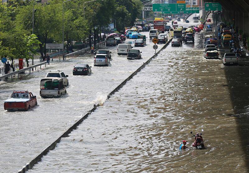 Vehicles drive through a flooded road in Bangkok, Thailand. Several major streets in the Thai capital were submerged by floodwater triggered by heavy rainfall.  EPA / STR.