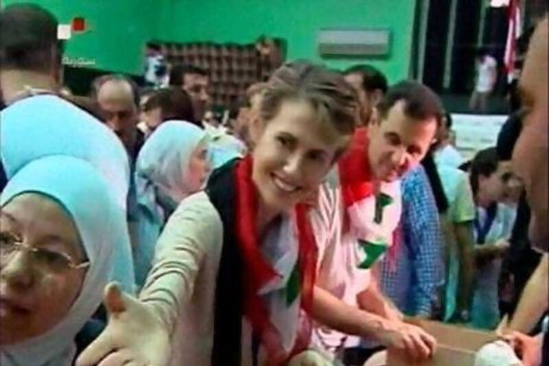 Asma Al Assad and her husband, President Bashar Al Assad, deliver food aid at a distribution centre in Damascus in this still image from a video shown on Syrian state television.