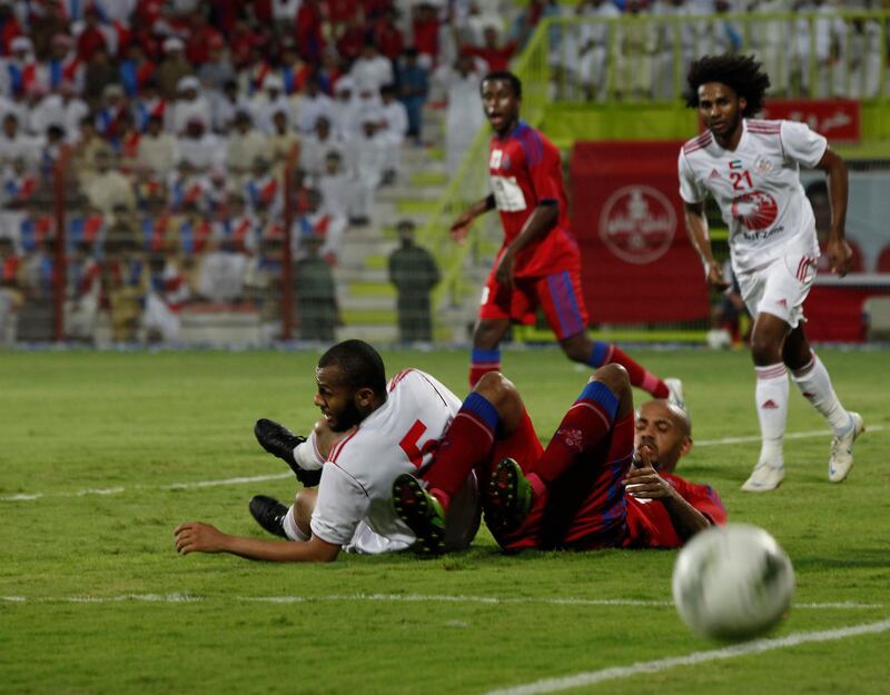 Dubai, United Arab Emirates - September 9, 2012.  Sharjah in white ( no 5 ) down together with an unidentified Al Shaab player.  ( Jeffrey E Biteng / The National )  Editor's Note; please refer to the players list written in Arabic.