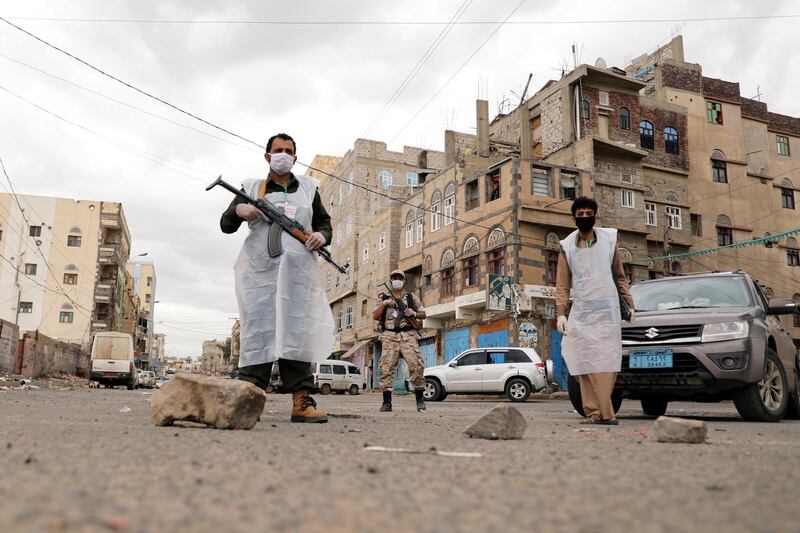 Security men wearing protective masks stand on a street during a 24-hour curfew in Sanaa, Yemen. Reuters